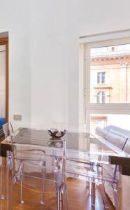 ローマにあるLive in The Heart of Romeの窓付きの客室で、ガラスのテーブルと椅子が備わります。