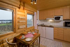 a kitchen with a table and a dining room at Matkailutila Lahdelma in Pertunmaa