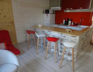 una cucina con bancone e 4 sgabelli rossi di LA BELLE D'ANTAN a Saint-Bonnet-en-Bresse