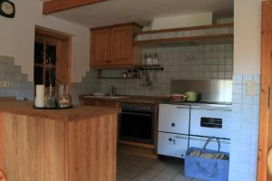eine Küche mit Holzschränken und einem weißen Herd mit Backofen in der Unterkunft Das Schäferhäuschen - Leitenbauer Schäferei in Vorau