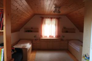 Schlafzimmer im Dachgeschoss mit 2 Betten und einem Fenster in der Unterkunft Das Schäferhäuschen - Leitenbauer Schäferei in Vorau
