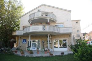 a large house with a balcony on top of it at Apartments Vujosevic in Tivat