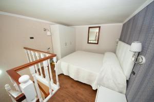 ein kleines Schlafzimmer mit einem weißen Bett und einer Treppe in der Unterkunft Daniela House 3 in Anzio