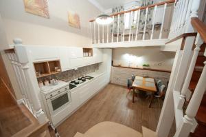 eine Küche mit weißen Schränken und einem Tisch darin in der Unterkunft Daniela House 4 in Anzio