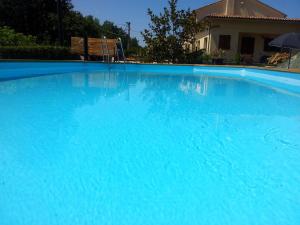 ein großer blauer Pool mit einer Bank darin in der Unterkunft B&B La Fenice in Montegridolfo
