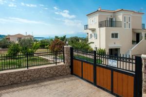 a gate in front of a house with a fence at Villa Hermes in Porto Heli