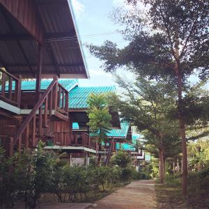 una fila de casas con escaleras de madera y árboles en Rasta House,,Koh Phayam en Ko Phayam
