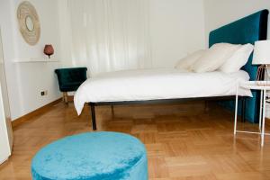 a bedroom with a bed and a blue ottoman at La Terrazza di Isabel in Rome