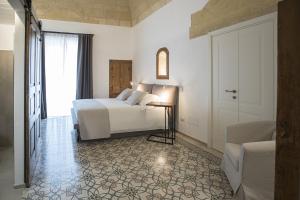 a bedroom with a bed and a table and a window at Palazzo Montemurro in Matera