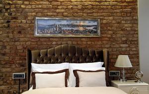 Cama en habitación con pared de ladrillo en Frida Suites, en Estambul