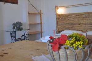 a room with a table with flowers on it at Apartments Scopello Inside in Scopello +23 photos
