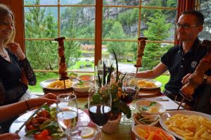 穆奧塔塔爾的住宿－赫斯基洛基弧騰酒店，一群人坐在餐桌旁吃着食物
