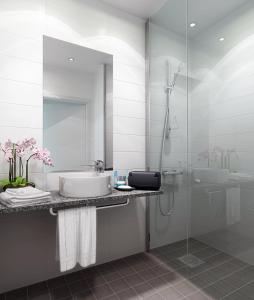 a white bathroom with a sink and a shower at Quality Hotel Friends in Solna