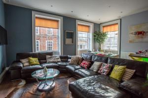 ein Wohnzimmer mit einem Ledersofa und einem Glastisch in der Unterkunft Most central luxury apartment - sleeps 4 & FREE parking! in Chester