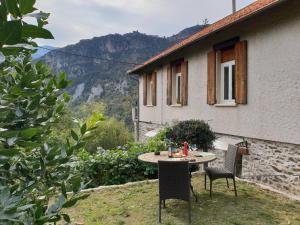 une table et des chaises assises à l'extérieur d'une maison dans l'établissement villa pura vida, à Saint-Martin-Vésubie