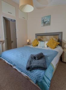 Un dormitorio con una cama azul con almohadas amarillas en Haggerston Lola the Lodge and Betty the Van en Cheswick