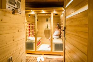 a woman is sitting in a sauna at Magnat Inn & Sauna & Relax in Zakopane