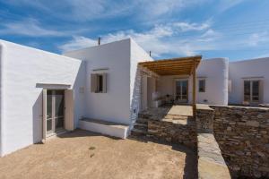 a white house with a stone wall at Katavati - 2 Semi-detached Houses in Apollonia