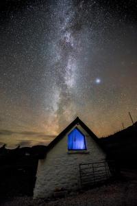 un granero con una ventana azul en el cielo nocturno en The Barn Culnacnoc, en Culnacnoc