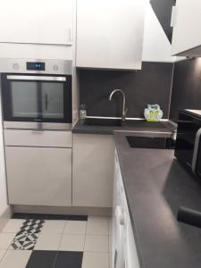 a kitchen with white cabinets and a sink at Palm beach Cannes Azur in Cannes