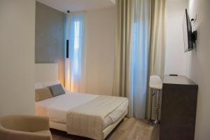 a bedroom with a bed and a desk and a chair at ApartHotel Durini in Milan