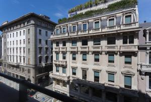 two tall buildings with plants on top of them at ApartHotel Durini in Milan