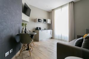 a living room with a couch and a table and a kitchen at ApartHotel Durini in Milan