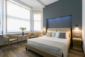 a bedroom with a large bed and two chairs at ApartHotel Durini in Milan