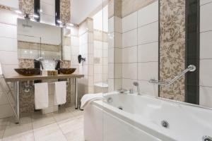 a white bathroom with a tub and a sink at ApartHotel Durini in Milan +98 photos