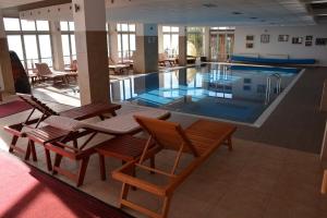 a large swimming pool with chairs and tables in a building at Apartman Sladjana Premier 12 Milmari in Kopaonik