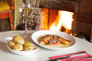 a table with a bowl of food and a glass of wine at The Rusty Mackerel in Teelin