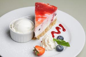 a piece of cake with ice cream and berries on a plate at The Rusty Mackerel in Teelin