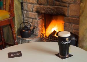 a cup of coffee sitting on a table in front of a fireplace at The Rusty Mackerel in Teelin