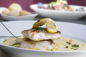 a plate of food with fish with a lemon on top at The Rusty Mackerel in Teelin