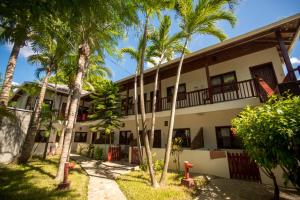 a building with palm trees in front of it at Splash Inn Dive Resort & Villas in West End