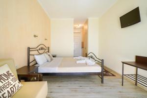 1 dormitorio con 1 cama, TV y sofá en Villa Mare Nostrum, en Limenaria