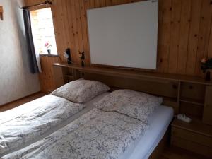 a bed in a room with a blank board above it at Ferienwohnung Kupfer in Schmiedefeld am Rennsteig