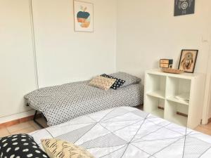 - une chambre avec 2 lits et une étagère dans l'établissement Superbe ! Appart T3 - Vue mer - Garage, à Palavas-les-Flots
