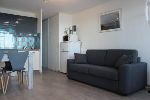 a living room with a couch and a kitchen at Nicolas Lambert - Appartement vue mer, prêt de velos,WIFI in Quiberon