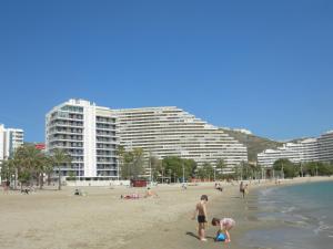 a group of people on a beach with buildings at Apartamento Florazar 2, 8ºC in Cullera