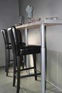 a table with a black chair sitting at it at Appartement Studio Tournai in Tournai
