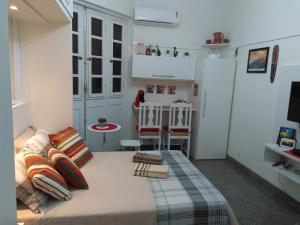 1 dormitorio pequeño con 1 cama y cocina en Charmoso Studio Ipanema, en Río de Janeiro