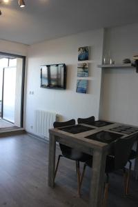 a kitchen with a table and a stove in a room at Nicolas Lambert - Appartement vue mer, prêt de velos,WIFI in Quiberon