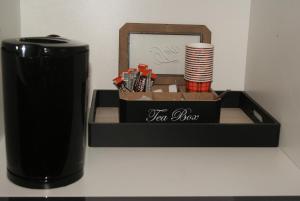 a black tea box with a stack of cups at Appartement Studio Tournai in Tournai