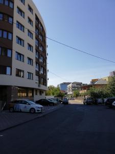 un estacionamiento con autos estacionados al lado de un edificio en Kolonaki Domus Apartment, en Iaşi