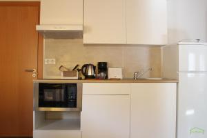 a kitchen with white cabinets and a microwave at CAL GENERAL in La Cellera de Ter