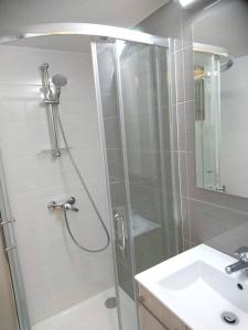a shower with a glass door next to a sink at By The Way Apartment in Larnaca +21 photos