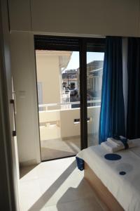 een slaapkamer met een bed en uitzicht op een balkon bij By The Way Apartment in Larnaka