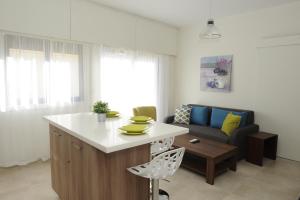 a kitchen and living room with a couch and a table at By The Way Apartment in Larnaca