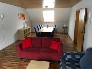 a living room with a red couch and a table at Haus Nova am Bollerberg in Hallenberg